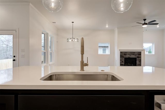 2348 Ridge Pine Rd, Edmond, OK 73034 - kitchen featuring open floor plan, plenty of natural light, light countertops, a kitchen island with sink, and crown molding