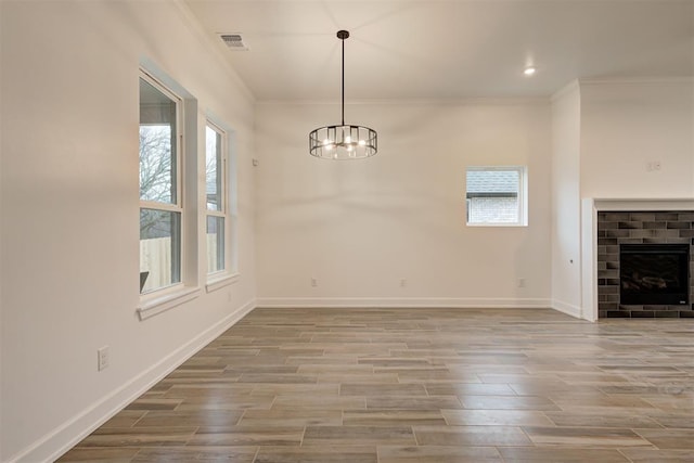 2348 Ridge Pine Rd, Edmond, OK 73034 - unfurnished dining area with crown molding, a chandelier, wood finished floors, and a fireplace