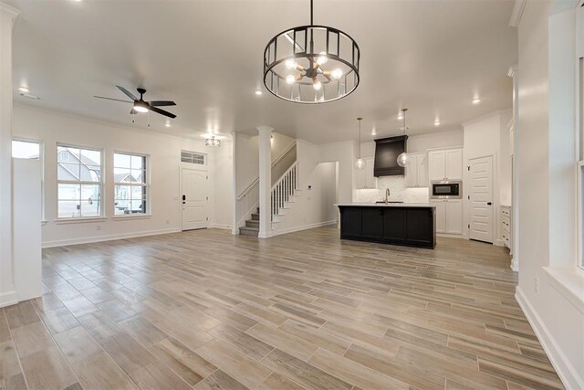 2348 Ridge Pine Rd, Edmond, OK 73034 - unfurnished living room featuring ceiling fan, stairway, light wood-style floors, recessed lighting, and crown molding