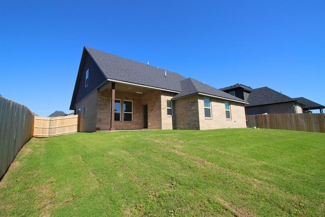 2348 Ridge Pine Rd, Edmond, OK 73034 - rear view of property with brick siding, a fenced backyard, and roof with shingles