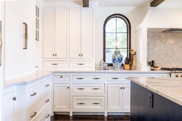 kitchen featuring decorative backsplash, dark hardwood / wood-style floors, white cabinetry, and light stone counters