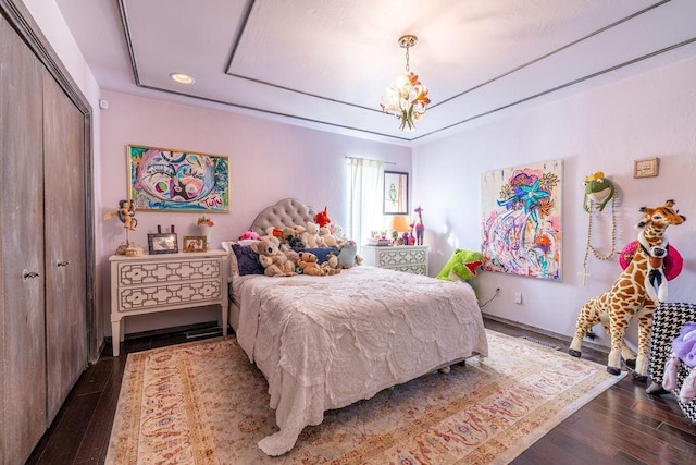 bedroom with an inviting chandelier, a closet, and dark wood-type flooring