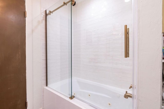 bathroom with bath / shower combo with glass door