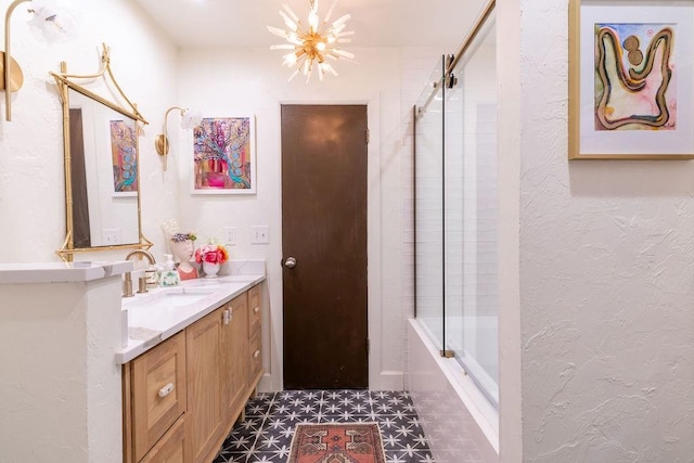 bathroom featuring tile patterned flooring, vanity, a chandelier, and combined bath / shower with glass door