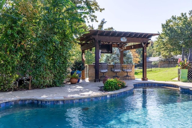 view of swimming pool with a pergola, a yard, and a bar