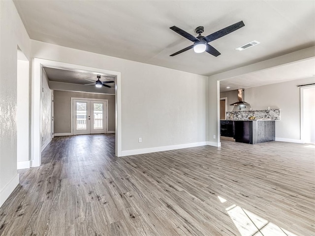 unfurnished living room featuring ceiling fan, wood-type flooring, and french doors