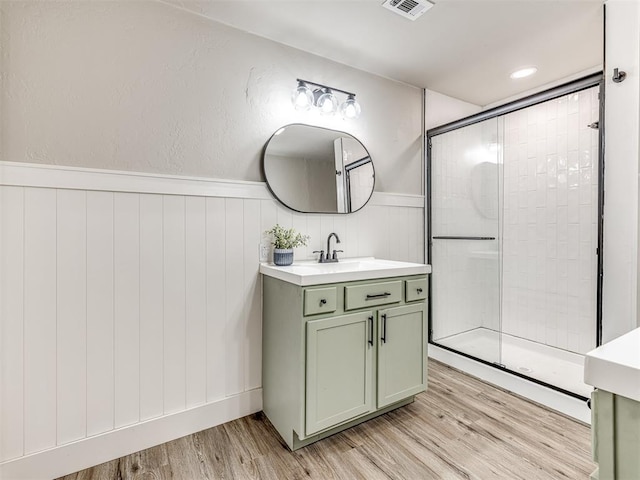 bathroom with vanity, wood-type flooring, and walk in shower