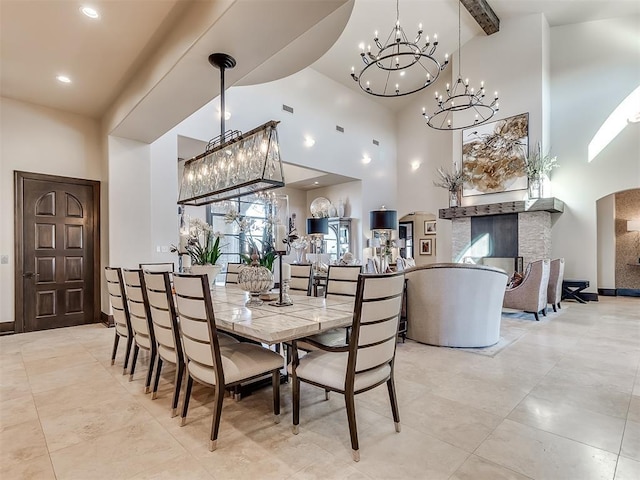 dining space featuring beamed ceiling and a high ceiling