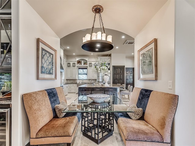 living room featuring wine cooler, lofted ceiling, and sink