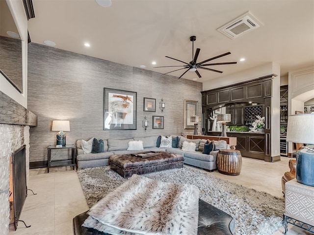 living room featuring ceiling fan, light tile patterned flooring, and a fireplace