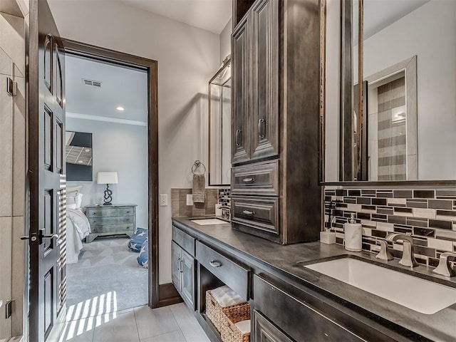 bathroom with tile patterned floors, decorative backsplash, vanity, and ornamental molding