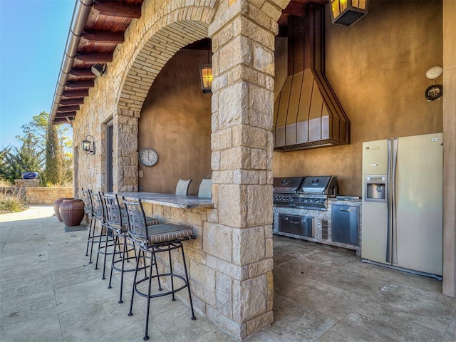 view of patio with exterior bar, grilling area, and exterior kitchen