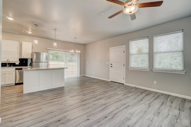 kitchen featuring white cabinets, stainless steel appliances, light wood-type flooring, and a kitchen island