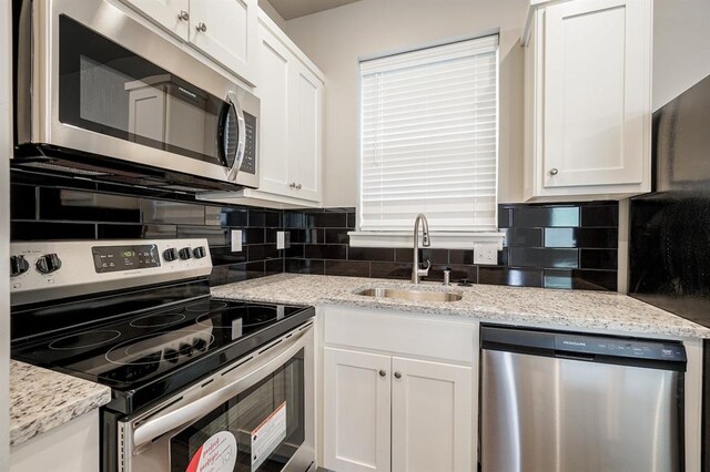 kitchen featuring white cabinets, sink, appliances with stainless steel finishes, and tasteful backsplash