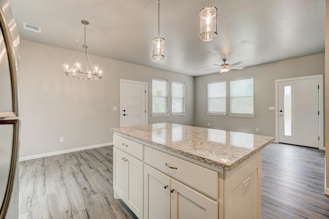 kitchen featuring a kitchen island, pendant lighting, ceiling fan with notable chandelier, and light wood-type flooring