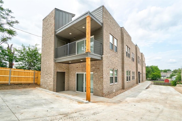 back of house featuring a patio area and a balcony