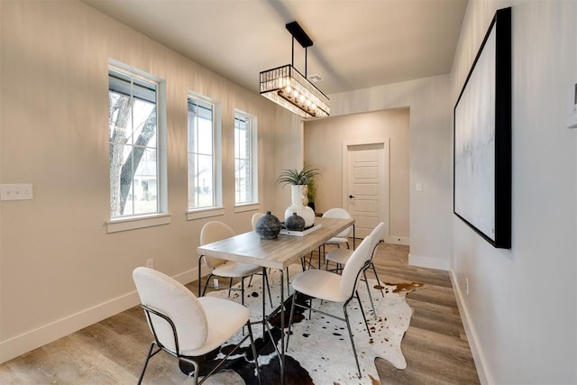 dining space featuring light hardwood / wood-style floors and an inviting chandelier