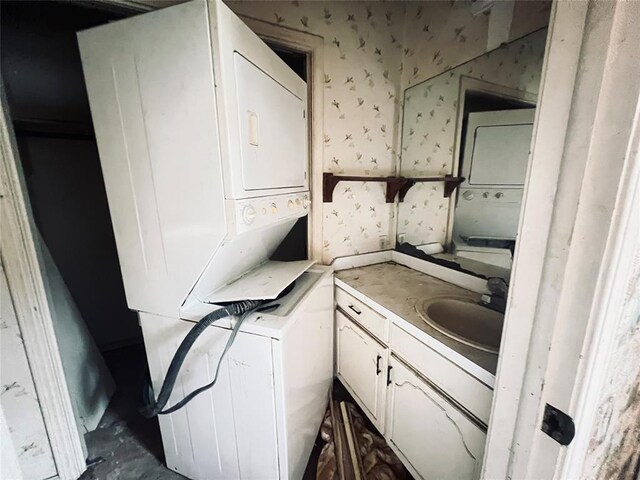 washroom with stacked washer and dryer and sink