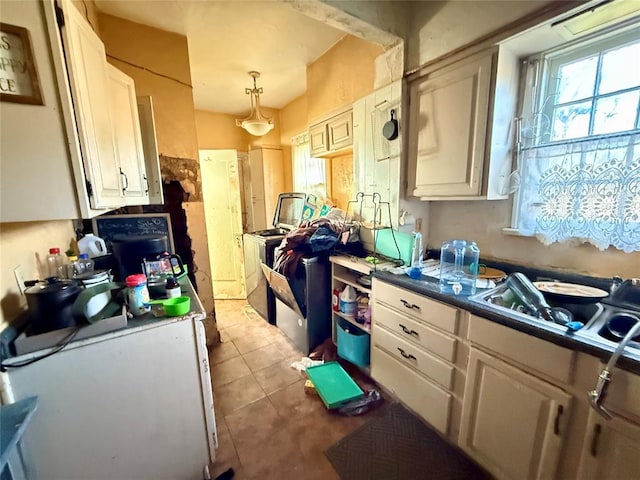 kitchen featuring white cabinets, tile patterned flooring, and hanging light fixtures