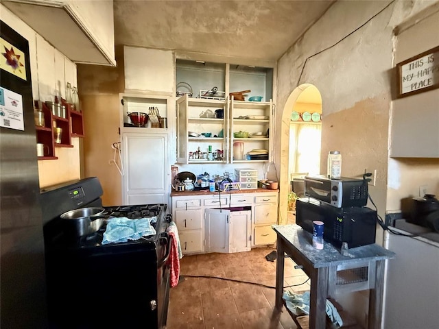 kitchen featuring white cabinets, black gas stove, and butcher block countertops