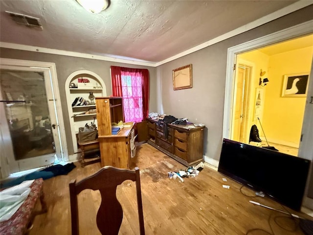 miscellaneous room featuring hardwood / wood-style floors, built in features, and a textured ceiling