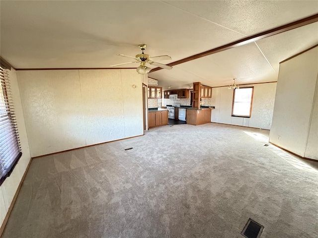 unfurnished living room featuring a ceiling fan, baseboards, lofted ceiling with beams, and light colored carpet