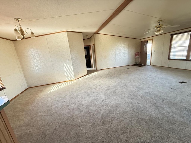 carpeted spare room with baseboards, vaulted ceiling, a textured wall, and ceiling fan with notable chandelier