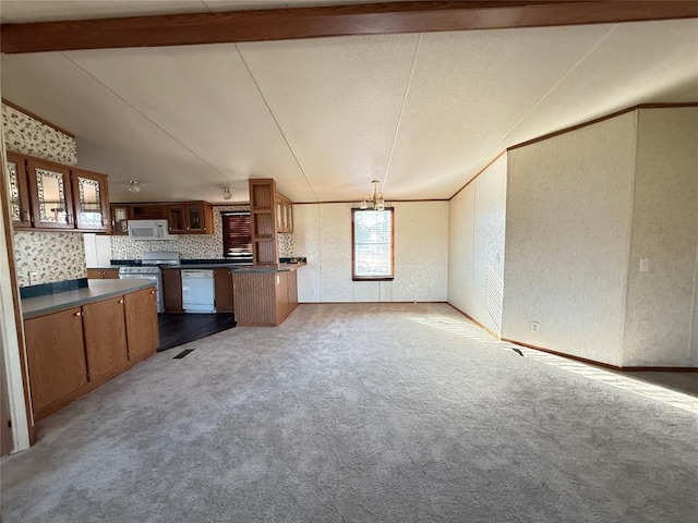 kitchen featuring carpet flooring, dark countertops, and white appliances