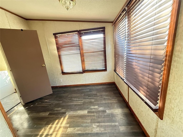 spare room with ornamental molding, dark wood finished floors, a textured ceiling, and lofted ceiling