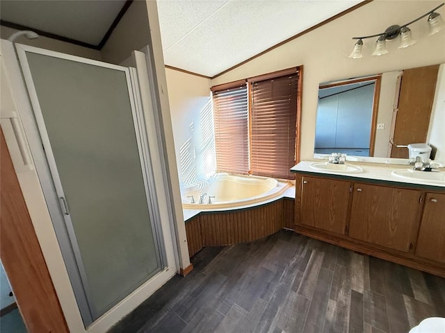bathroom featuring a garden tub, a sink, wood finished floors, and a shower stall