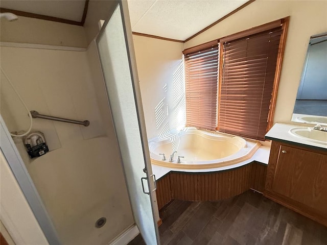 bathroom with a garden tub, a textured ceiling, a shower stall, wood finished floors, and vanity