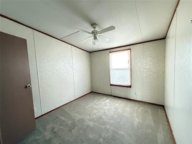 unfurnished room with baseboards, ceiling fan, carpet, and a textured wall