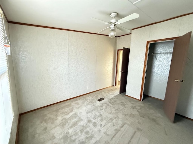 unfurnished bedroom featuring crown molding, carpet, and a textured wall
