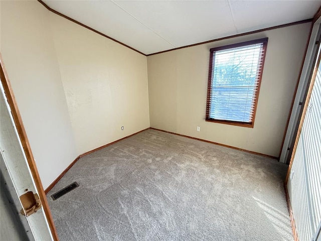 carpeted spare room with baseboards, ornamental molding, and visible vents