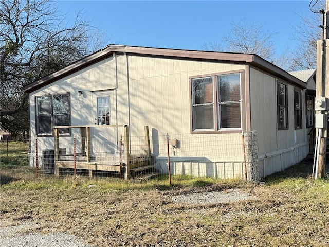 rear view of house with fence and central air condition unit
