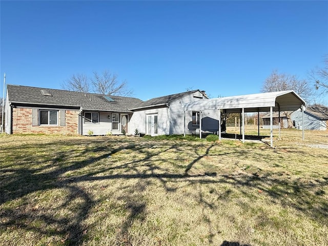 rear view of house with a carport and a yard