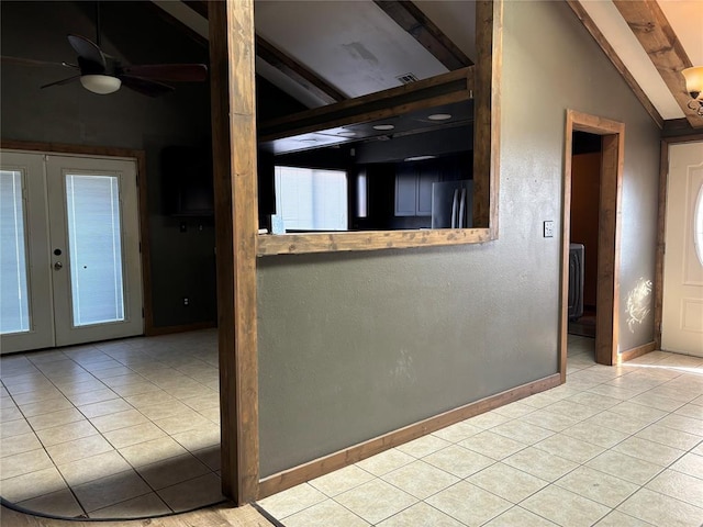 interior space featuring vaulted ceiling with beams, light tile patterned flooring, french doors, and ceiling fan