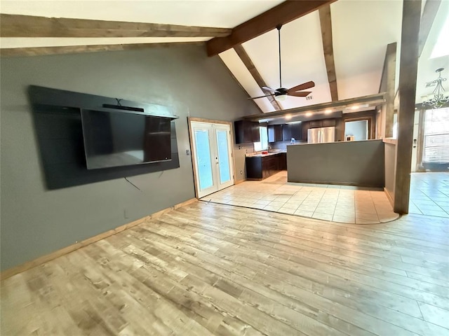 unfurnished living room with ceiling fan, light hardwood / wood-style floors, beam ceiling, high vaulted ceiling, and french doors