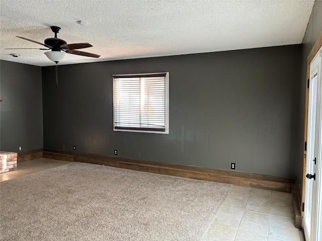 tiled empty room featuring ceiling fan and a textured ceiling