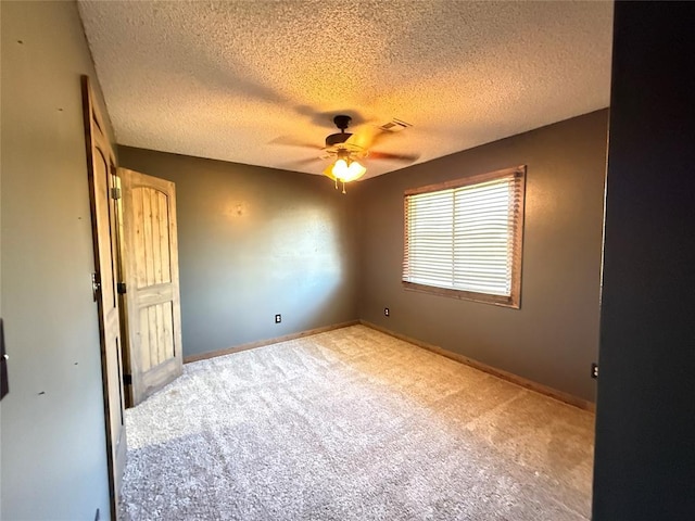 carpeted empty room with ceiling fan and a textured ceiling