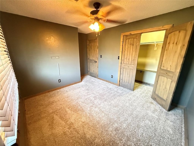 unfurnished bedroom featuring ceiling fan, a textured ceiling, a closet, and carpet flooring