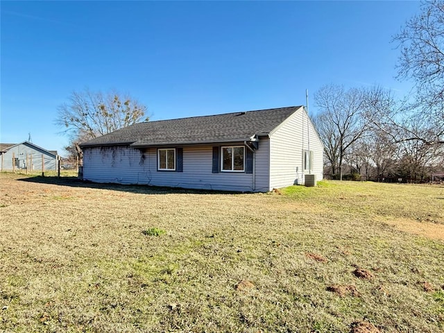 rear view of house featuring a lawn and central AC