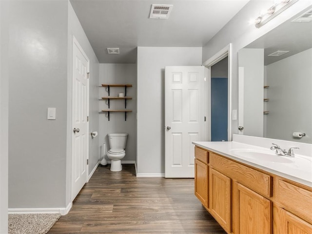 bathroom with vanity, wood-type flooring, and toilet