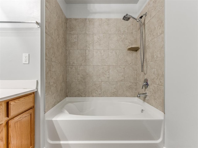 bathroom featuring vanity and tiled shower / bath