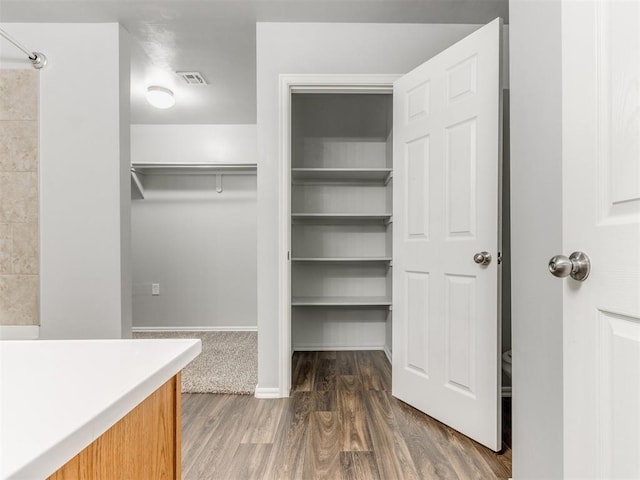 spacious closet featuring dark hardwood / wood-style floors