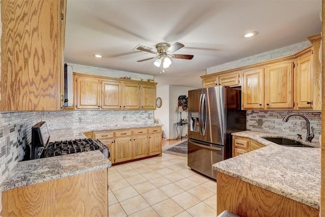 kitchen with ceiling fan, sink, tasteful backsplash, stainless steel refrigerator with ice dispenser, and stove