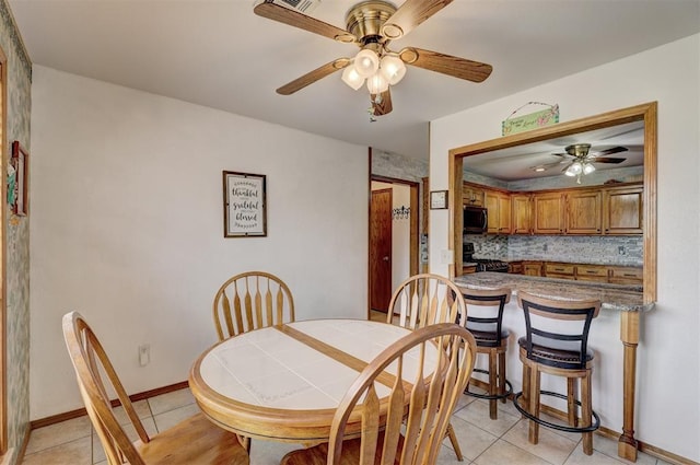 dining room with ceiling fan and light tile patterned flooring