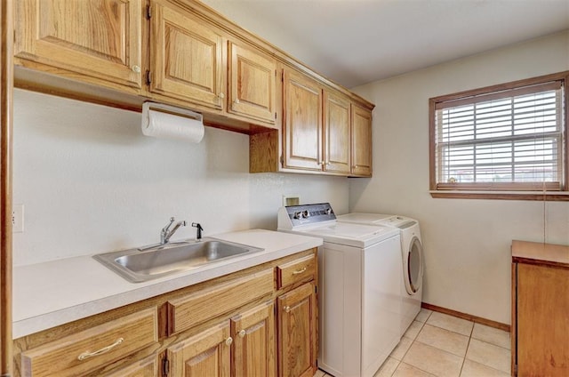 laundry room featuring separate washer and dryer, sink, light tile patterned floors, and cabinets