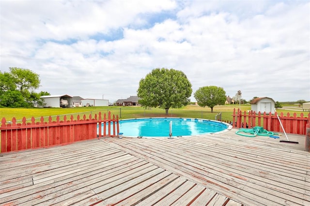 view of pool with a lawn and a wooden deck