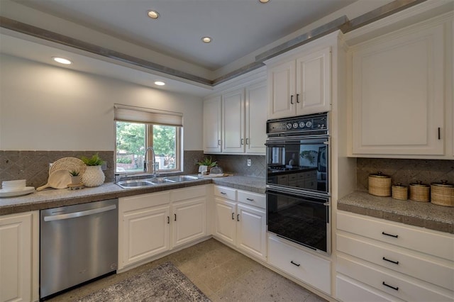 kitchen featuring sink, stainless steel dishwasher, double oven, backsplash, and white cabinets